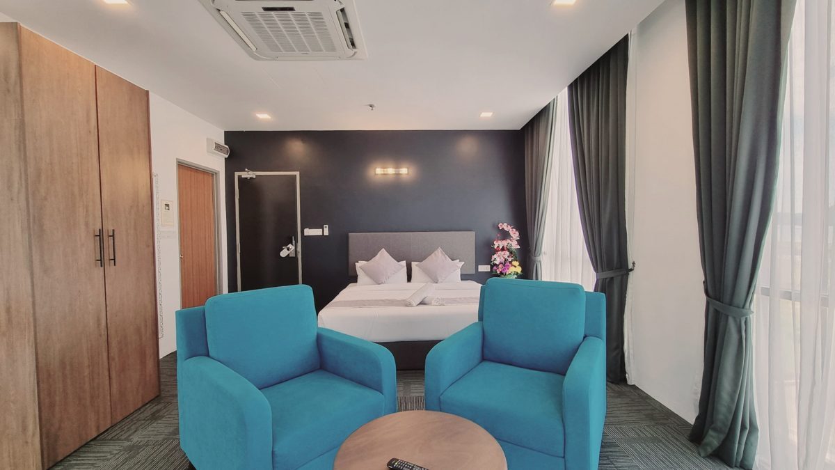 Suite Room with king bed and blue lounge chairs
