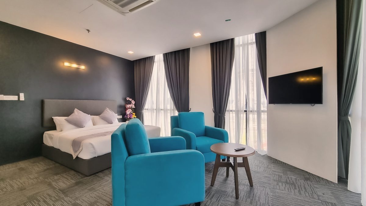 Suite Room with bed, lounge chairs and TV